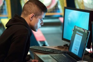 A man staring intently at his laptop screen