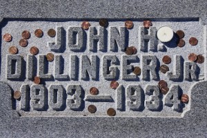 A grave marker for bank robber John Dillinger, scattered with coins