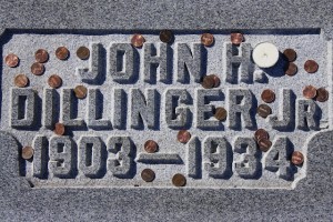 John Dillinger was a famous bank robber, back when banks weren't online. A grave marker for bank robber John Dillinger, scattered with coins
